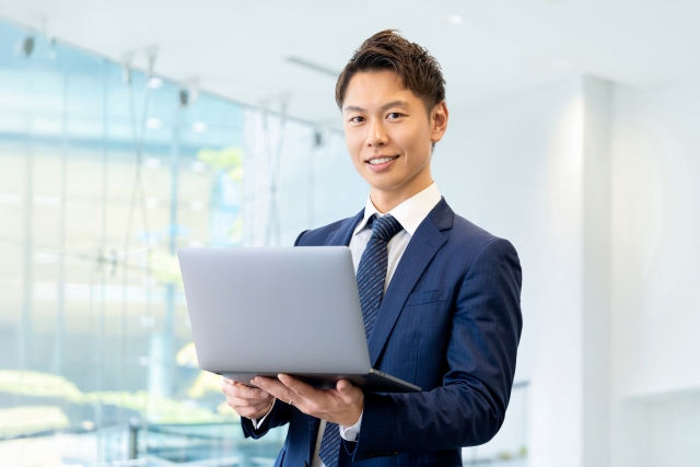 ノートパソコンを持つ男性